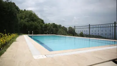 a large swimming pool with a fence around it at Orchid Hills - heated swimming pool in Sapanca