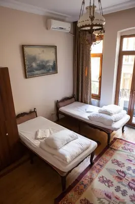 two twin beds in a room with a window at Chambers of the Boheme in Istanbul