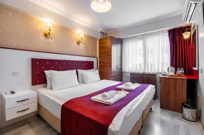 a bedroom with a large bed with towels on it at Cihangir Palace Hotel in Istanbul