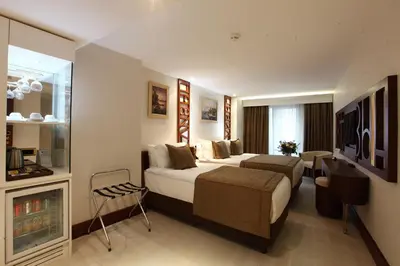 a hotel room with two beds and a chair at Victory Hotel & Spa Istanbul in Istanbul