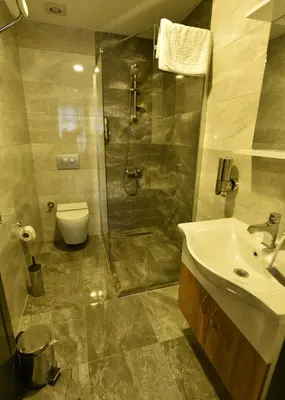 a bathroom with a shower and a sink and a toilet at Sahil Hotel Pendik in Tuzla