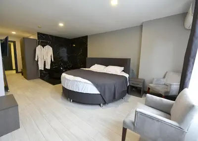 a bedroom with a bed and a chair and a couch at Sahil Hotel Pendik in Tuzla
