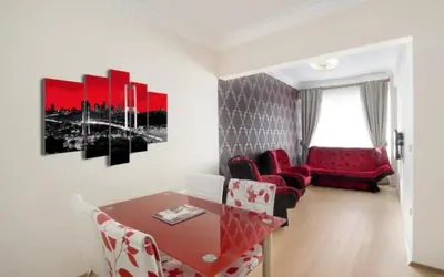 a living room with a table and red chairs at ELMİR SUİTES Hotel in Istanbul