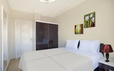 a white bedroom with a white bed and a window at ELMİR SUİTES Hotel in Istanbul