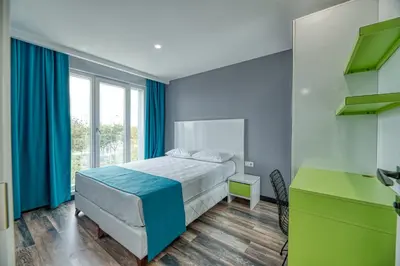 a bedroom with a bed with blue curtains and a desk at Grisverde Suites in Istanbul