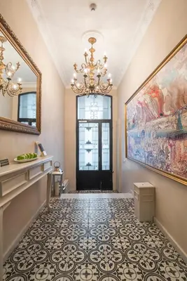 a hallway with a chandelier and a large painting at Louis Appartements Galata in Istanbul