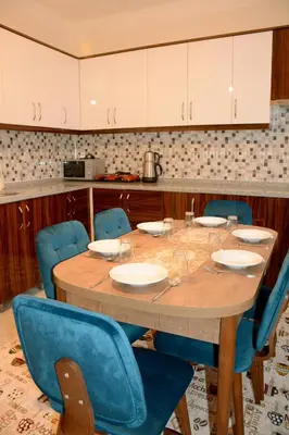 a table in a kitchen with blue chairs around it at Şar Apartment Suites in Istanbul
