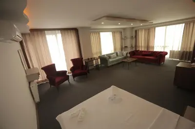 a large living room with red chairs and a couch at TEVETOGLU HOTEL in Istanbul