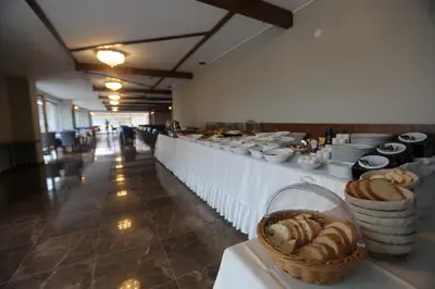 a buffet line with white tables and baskets of bread at TEVETOGLU HOTEL in Istanbul