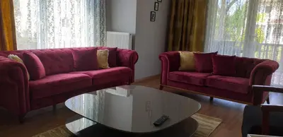 a living room with two red couches and a coffee table at PALACE KIRKPINAR in Sakarya