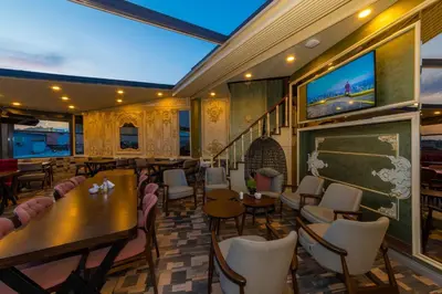 a restaurant with tables and chairs and a tv at Golden Sand Hotel in Istanbul