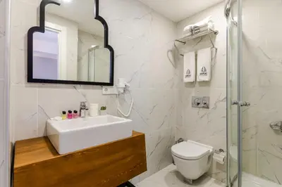 a bathroom with a sink and a toilet and a mirror at DORUK PALAS HOTEL in Istanbul