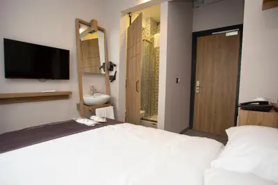 a bedroom with a bed and a sink and a television at Jurnal Hotel in Istanbul