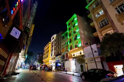 a city street at night with green lights on a building at Hotel Bestur in Istanbul