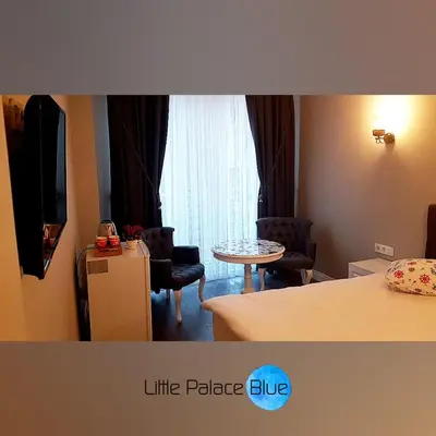 a room with a bed and a table and a window at Little Palace Blue Apartment in Istanbul