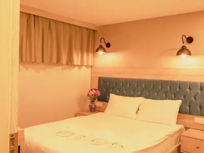 a bedroom with a bed with white sheets and flowers at THE LAİLA HOTEL in Istanbul