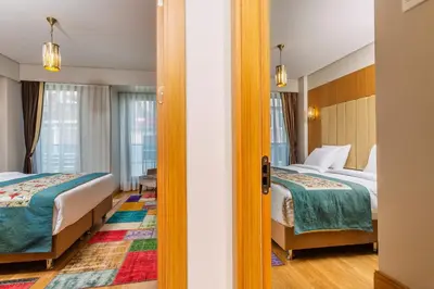 a hotel room with two beds and a doorway at Obelisk Hotel & Suites in Istanbul