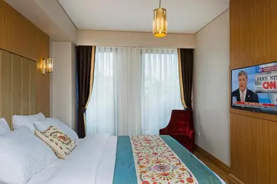 a hotel room with a bed and a flat screen tv at Obelisk Hotel & Suites in Istanbul