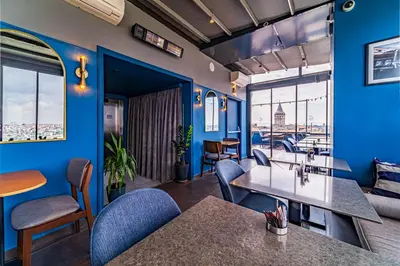 a room with blue walls and tables and chairs at Galata Times Hotel in Istanbul