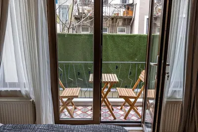 a room with a balcony with two chairs and a window at Calanthe Residence in Istanbul