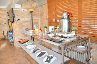 a kitchen with a table with food on it at Elite Hotel City Center Saray Bed and Breakfast in Saray