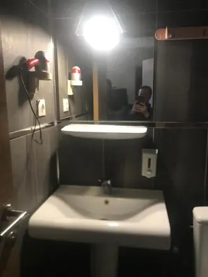 a person taking a picture of a bathroom sink at Elite Hotel City Center Saray Bed and Breakfast in Saray