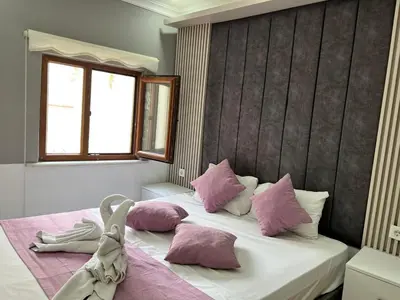 a bedroom with a bed with pink and white pillows at The Zanadu İstanbul in Istanbul