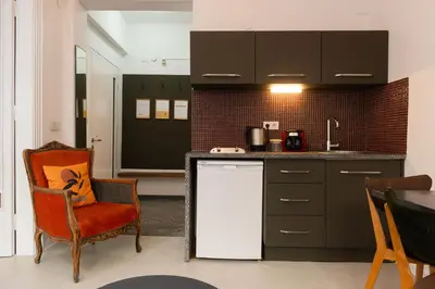 a kitchen with an orange chair and a counter at Mayer Tatarbey Apartments in Istanbul