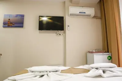 a room with two beds with a tv on the wall at Reggae in Istanbul