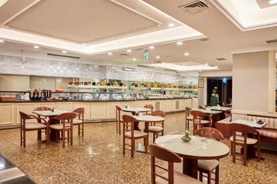 a restaurant with tables and chairs and a kitchen at Konak Hotel Taksim in Istanbul