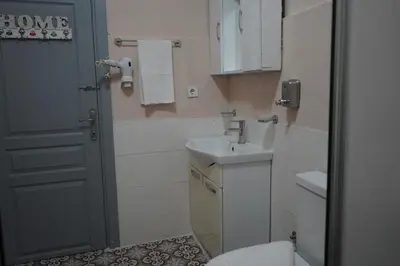 a bathroom with a sink and a toilet and a door at Medellin Apart Hotel Istanbul in Istanbul
