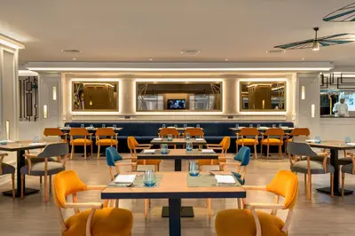 a restaurant with tables and chairs and a bar at Occidental Taksim in Istanbul
