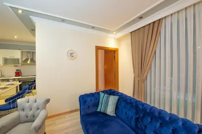 a living room with a blue couch and a kitchen at Three bedroom Duplex apartment with large terrace in Istanbul