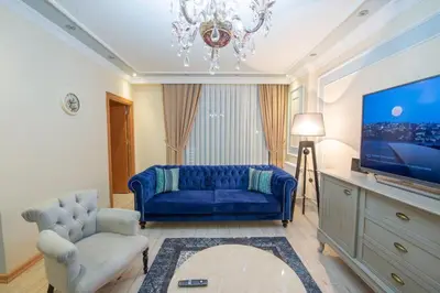 a living room with a blue couch and a tv at Three bedroom Duplex apartment with large terrace in Istanbul