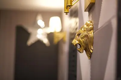 a gold door handle with a gold head on a wall at Four Sides Taksim Lion Hotel&Spa in Istanbul
