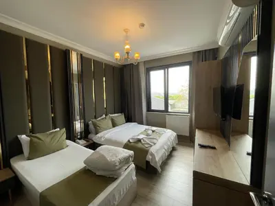 a hotel room with two beds and a flat screen tv at New Taksim Hotel in Istanbul