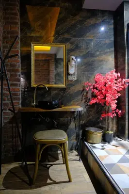a stool in a room with a mirror and flowers at Kayıbeyi Hotel & Restaurant in Bursa