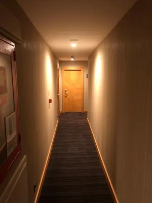 a hallway with a wooden door and a long aisle at Maywood Hotel in Istanbul