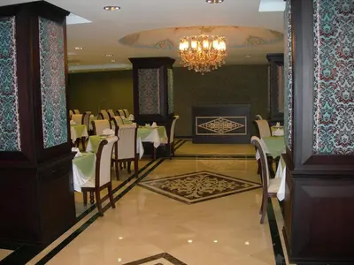 a dining room with tables and chairs and a chandelier at Maywood Hotel in Istanbul