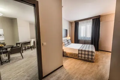 a hotel room with a bed and a dining room at Karinna Hotel Convention Center & Spa Luxury - Full Board Plus in Uludag