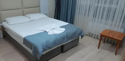 a bedroom with a bed and a wooden table at Arya Hotel in Istanbul