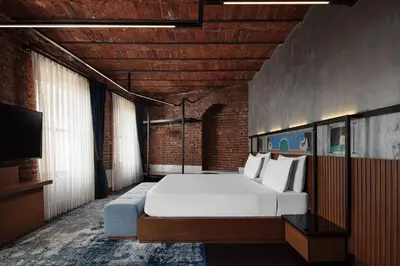 a bedroom with a large bed and a television at DeCamondo Galata, a Tribute Portfolio Hotel in Istanbul