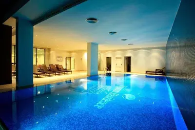 a large swimming pool in a building with blue lighting at CTS Elysium Residence Duplex Apt. 85 in Istanbul