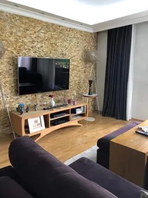 a living room with a television on a brick wall at Boğazın incisi.. in Istanbul