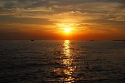 a sunset over the ocean with a boat at istanbul Airport Kumsal Otel in Arnavutköy