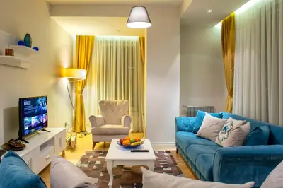 a living room with a blue couch and a tv at Armoni Residence & Hotel in Istanbul