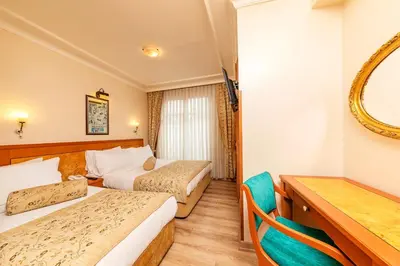 a hotel room with two beds and a mirror at Santa Ottoman Hotel in Istanbul
