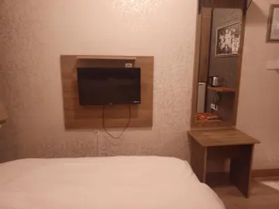 a bedroom with a bed and a tv on the wall at Kosk Hotel Kadikoy in Istanbul