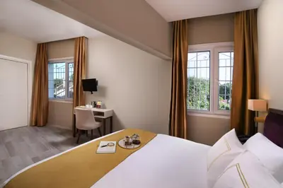 a hotel room with a bed and a desk and windows at Almina Hotel - Special Class in Istanbul