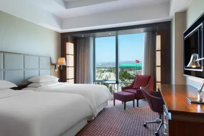 a hotel room with a bed and a desk and a window at Sheraton Bursa Hotel in Bursa